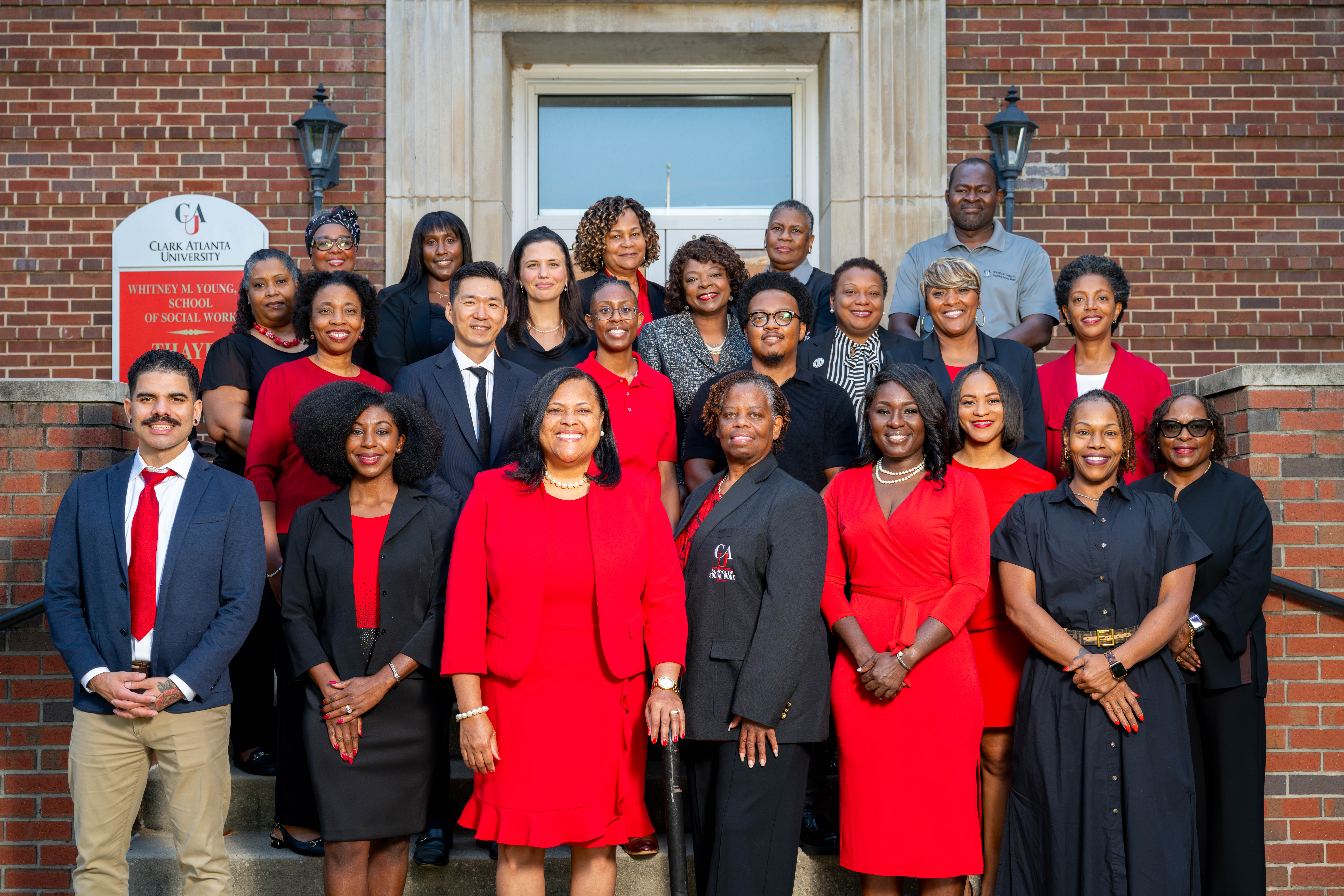WMYJSSW Faculty and Staff in formal attire, standing on steps outside a brick building.