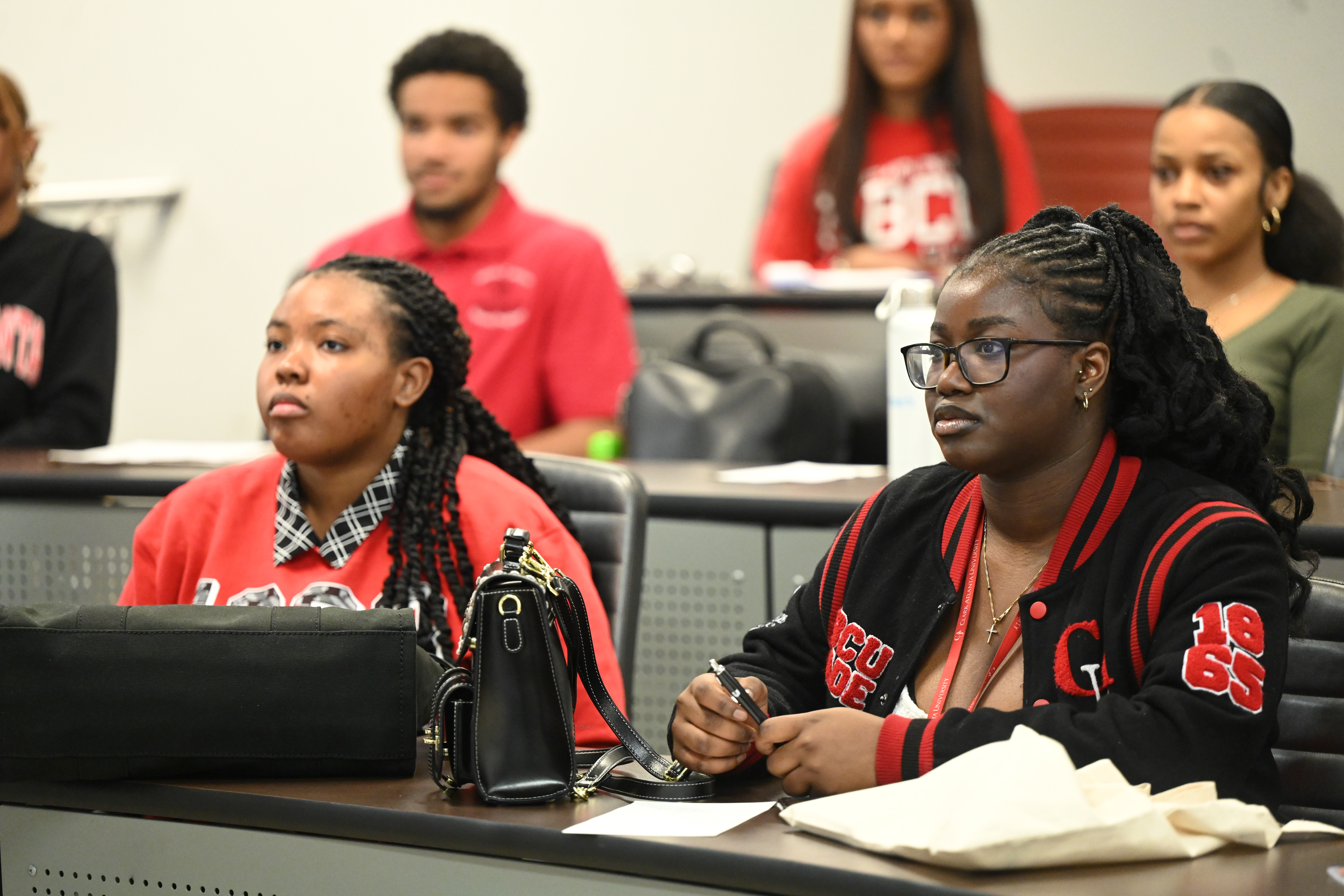 Students attentively listening in a classroom setting.