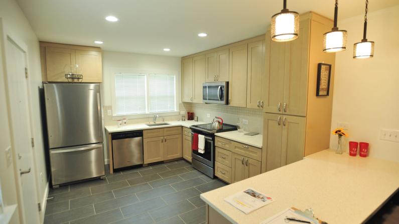 Modern kitchen with stainless steel appliances and light wood cabinets.