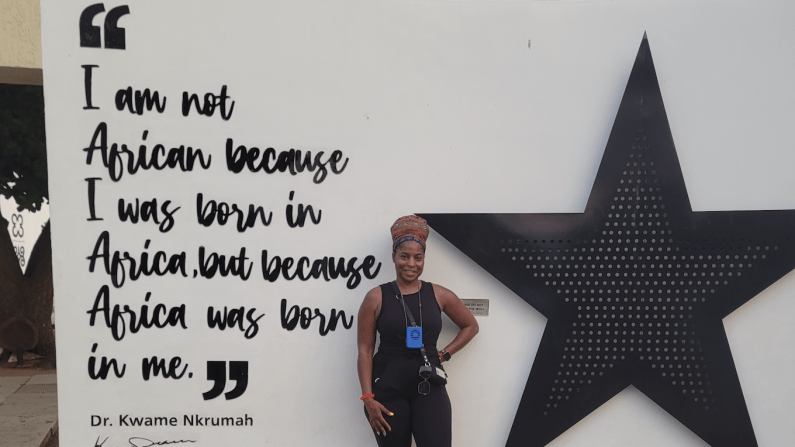 Person standing by a wall with a large black star and Kwamena Acquah quote.