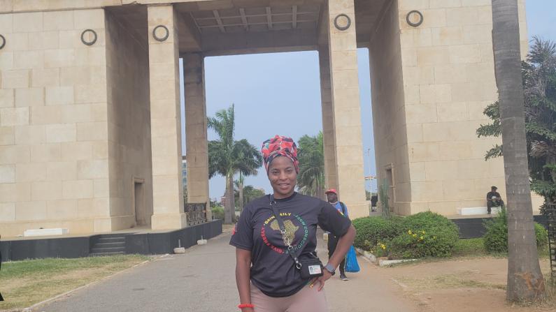 Person standing in front of a large stone archway with a star on top.