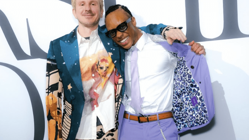 Two men in colorful suits, smiling and posing together.