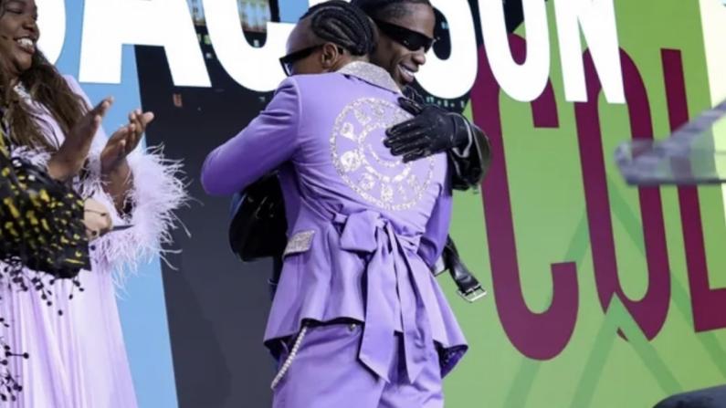 Travis Scott hugging Clark Atlanta University student Kuan Jackson at FSF Live 2026 event, with a cheering audience.