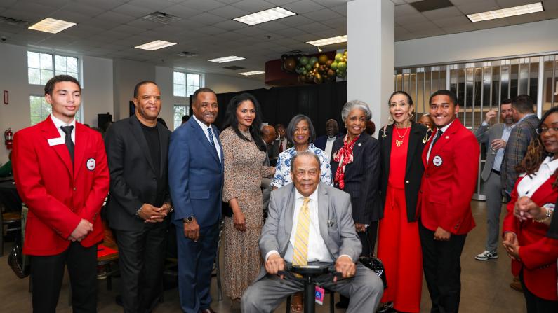 Group of people in formal attire smiling indoors.