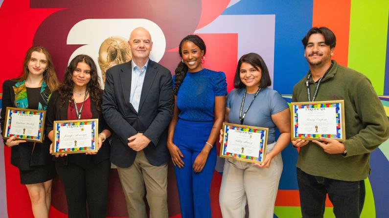 Clark Atlanta University Alumna Ebonee Bradley and others smiling, four holding certificates, standing against colorful wall.
