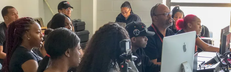 A group of people at computers in a classroom setting.
