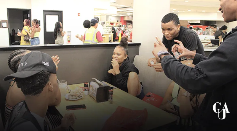Group of people smiling and conversing at a restaurant table.