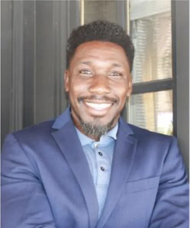 Ronald Cetoute Associate Director in a blue suit jacket against a windowed door background.