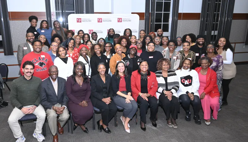 MSW Mixer with of people smiling together indoors, some seated front row.