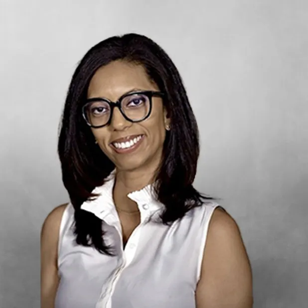Smiling woman in glasses and a sleeveless white blouse.