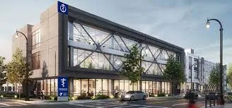 Modern three-story building with large windows and street view.