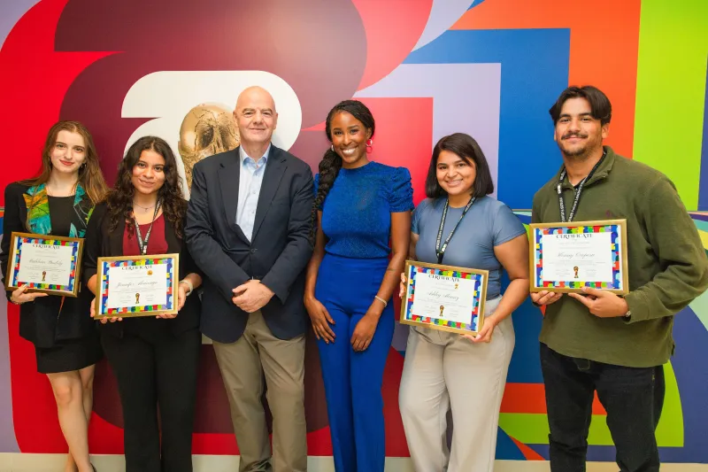 Clark Atlanta University Alumna Ebonee Bradley and others smiling, four holding certificates, standing against colorful wall.